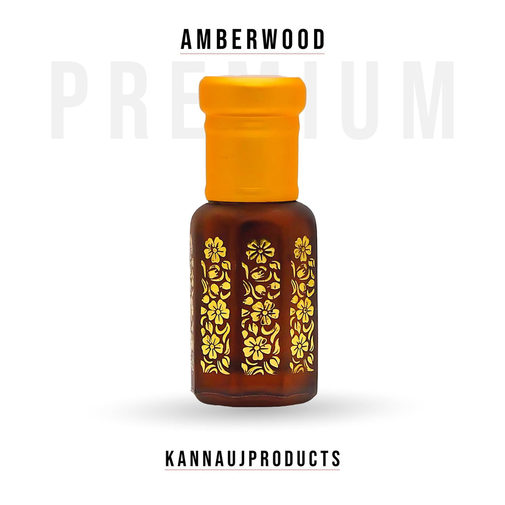Amber glass bottle with yellow cap and gold floral pattern containing amberwood attar perfume oil by Kannauj Products