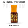 Small brown glass bottle with yellow cap and floral gold design containing Rajni Gandha attar for unisex. Kannauj Products